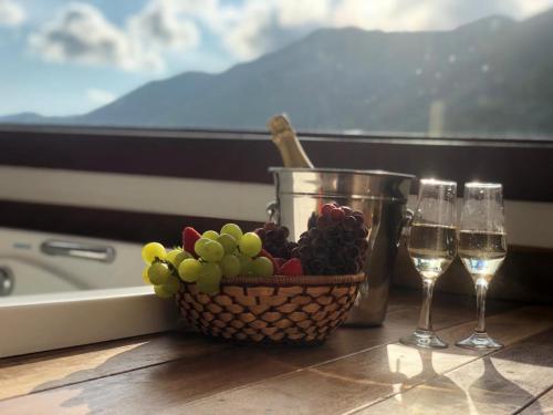 a basket of grapes and glasses of wine on a table at Hotel Recanto do Ouro in Ouro Preto
