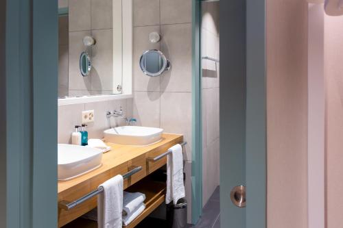 a bathroom with two sinks and a mirror at Cascada Boutique Hotel in Lucerne