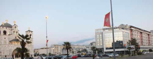 a building with a flag on top of it on a city street at Apartment Temple in Podgorica