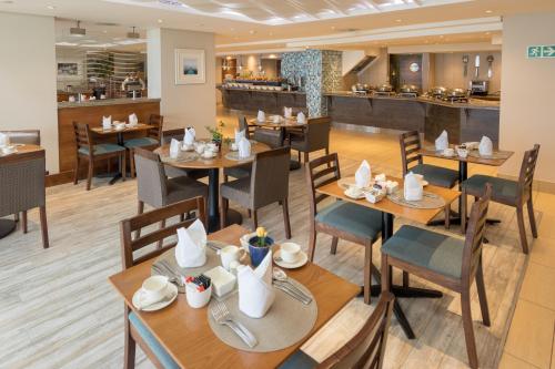 a restaurant with wooden tables and chairs and a cafeteria at Town Lodge Gqeberha in Port Elizabeth