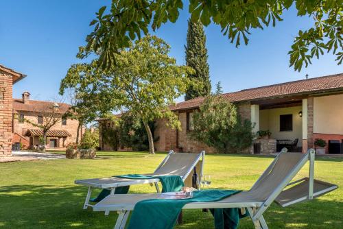 duas cadeiras e uma mesa num quintal em Country House Le Case Coloniche em Deruta