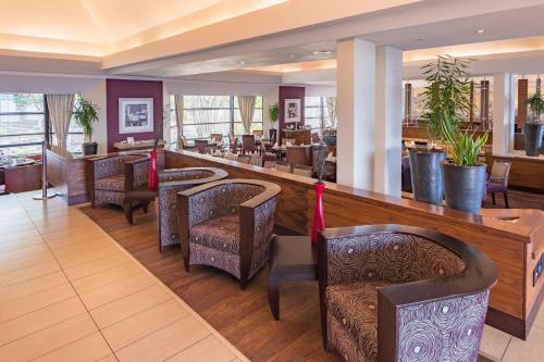 a restaurant with a bar with chairs and tables at City Lodge Hotel Gqeberha in Port Elizabeth