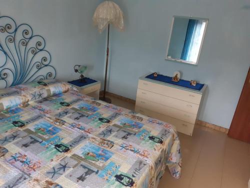 1 dormitorio con cama, tocador y espejo en casa aurora en Calatabiano