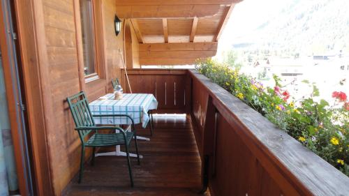 a porch with a table and a chair on a balcony at Ferienwohnungen Birnbacher in Sankt Ulrich am Pillersee