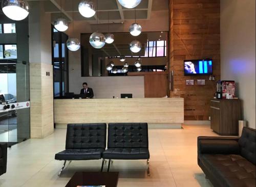 a lobby with chairs and a bar in a store at Edificio Crystal Place Ap1405 in Goiânia