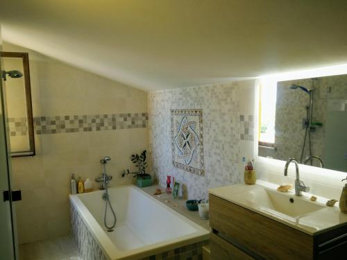 ein Badezimmer mit einer Badewanne und einem Waschbecken in der Unterkunft Due graziose camere con vista mare a 5 min dal mare di Castiglioncello in Castiglioncello