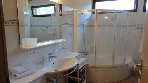 uma casa de banho com um lavatório e um chuveiro em Ferienwohnungen Birnbacher em Sankt Ulrich am Pillersee