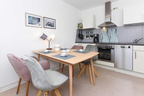 a small kitchen with a wooden table and chairs at Ferienhaus Nordseeliebe in Esens
