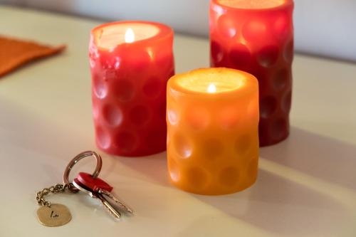 three candles and a pair of keys on a table at Residence Ferraud in Pinerolo