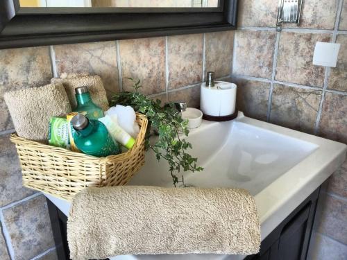 a bathroom sink with a basket of detergents on it at Traditional Villa Mandola in Kefallonia