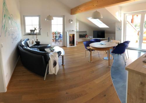 a living room with a couch and a table at Alpenglück de Luxe Ferienwohnung am Forggensee in Schwangau
