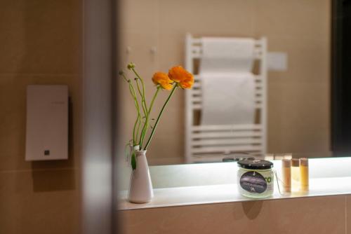 a vase with flowers in it sitting on a counter at Amberton Cathedral Square Hotel Vilnius in Vilnius