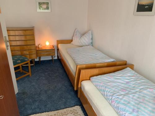 a room with two beds and a table with a lamp at Ferienwohnung Bünger in Essel