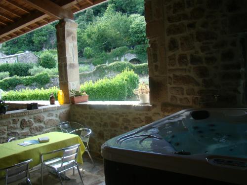 a bath tub in a room with a table and chairs at Chambre d'hôte avec jacuzzi in Sanilhac