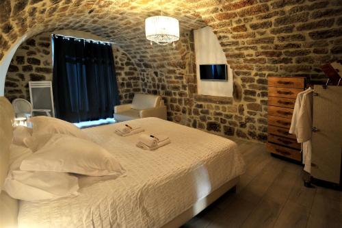 Sanilhac的住宿－Chambre d'hôte avec jacuzzi，一间卧室设有一张床和砖墙