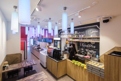 a woman standing at the counter of a restaurant at Hostel Warmoes Amsterdam in Amsterdam