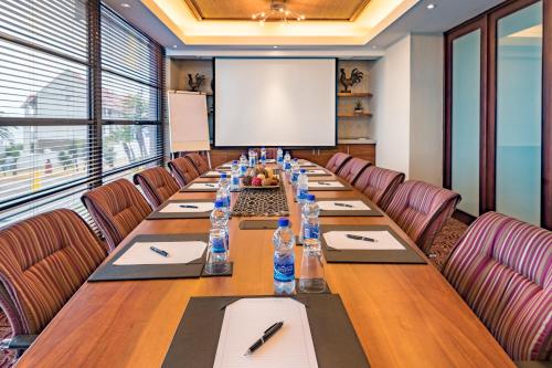 a long table in a conference room with a screen at City Lodge Hotel Gqeberha in Port Elizabeth