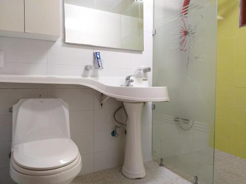 a white bathroom with a toilet and a sink at Namhea German Village Beethoven House in Namhae