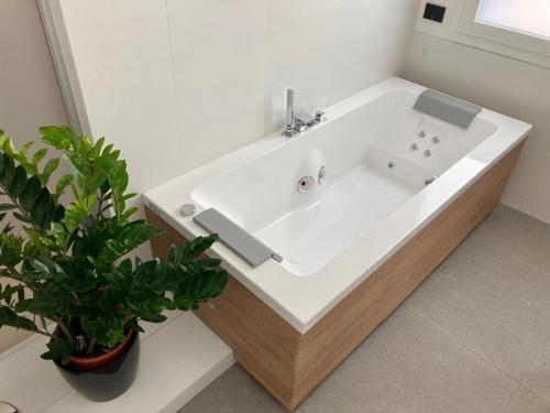 a white sink in a bathroom with two potted plants at Antica Pusterla Relais de Charme in Vicenza