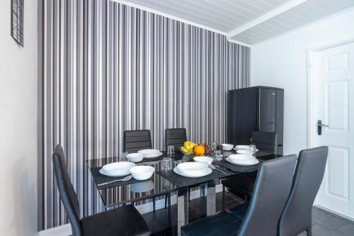 a dining room with a black table and chairs at CAPRI 13 SA - 3 Bedroom House close to Loughborough University, EV car facilities, Free Parking, Free Wifi - Ask for contractor rates! in Loughborough