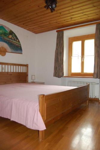 a bedroom with a large wooden bed in a room at Chasa Städler - Ferienwohnung mit 113m2 für max. 5 Personen in Zernez