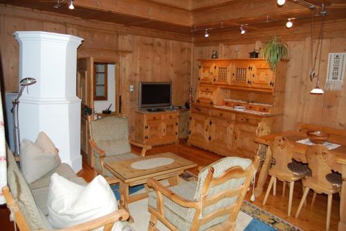 ein Wohnzimmer mit einem Tisch, Stühlen und einem TV in der Unterkunft Chasa Städler - Ferienwohnung mit 113m2 für max. 5 Personen in Zernez