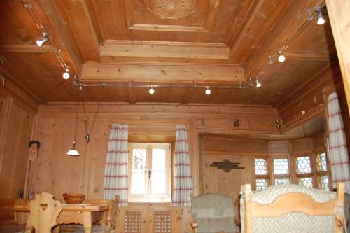 a room with a wooden ceiling with a table and a window at Chasa Städler - Ferienwohnung mit 113m2 für max. 5 Personen in Zernez