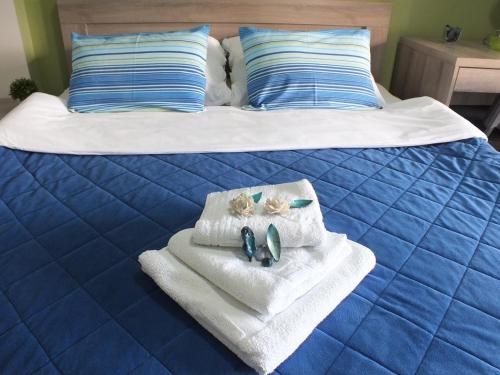 a bed with towels and shoes on top of it at Apartment Temple in Podgorica
