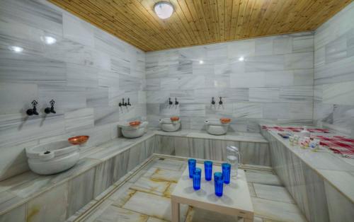 a bathroom with four sinks and blue glasses on a table at RIVER INN RESORT AND SPA in Nabran