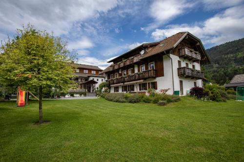 a building with a tree in the middle of a yard at Schullerhof in Hermagor