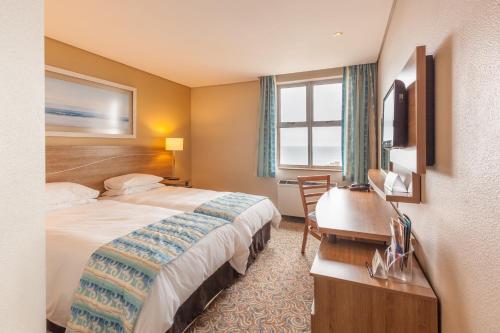 a hotel room with a bed and a desk at Town Lodge Gqeberha in Port Elizabeth