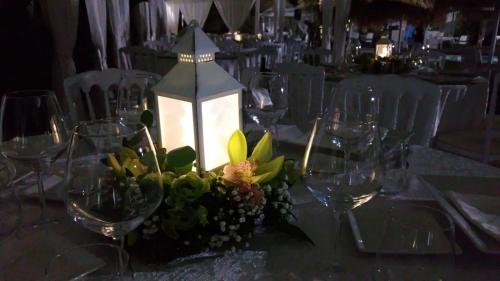 a table with wine glasses and a lantern on it at Sunshine Club Hotel Centro Benessere in Ricadi