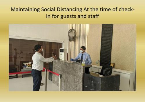 two men standing at a counter in an office at Hotel Deccan Serai, HITEC CITY, HYDERABAD in Hyderabad