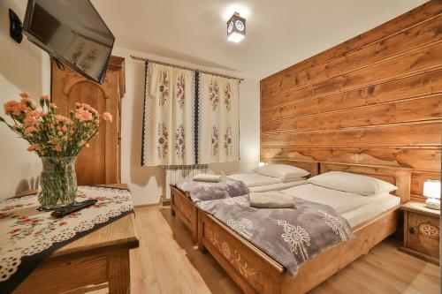 a bedroom with two beds and a vase of flowers at Agroturystyka Pokoje na Zakręcie in Białka Tatrzańska