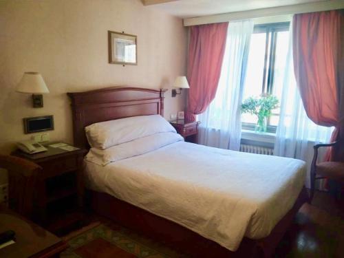 um quarto de hotel com uma cama e uma janela em Hostal Bahía em San Sebastián
