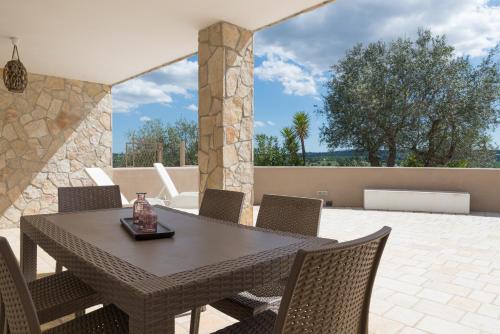 een houten tafel en stoelen op een patio bij Relax e Belvedere in Fasano