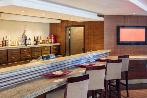 a bar in a hotel with chairs and a television at City Lodge Hotel Gqeberha in Port Elizabeth
