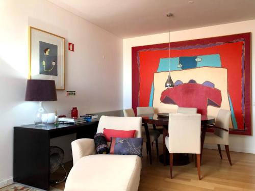 een woonkamer met een tafel en een schilderij bij Lisbon Chiado One in Lissabon