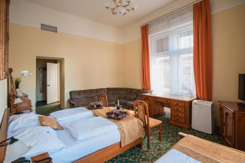 a bedroom with two beds and a table and a couch at City Hotel UNIO superior in Budapest