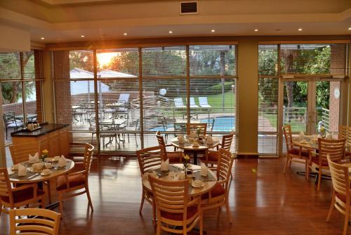 a dining room with tables and chairs and windows at Road Lodge Sandton in Johannesburg