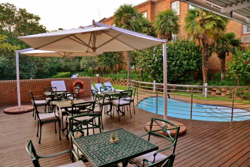 a deck with tables and chairs and an umbrella at Road Lodge Sandton in Johannesburg
