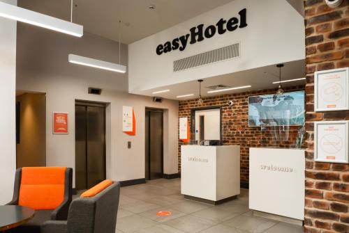 an office lobby with a sign for agas hotel at easyHotel Milton Keynes in Milton Keynes