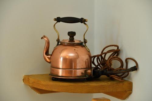 a tea kettle sitting on a wooden shelf at Beacon House B&B Brixham in Brixham