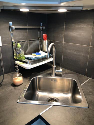 a stainless steel sink in a kitchen with a shelf at Chez Lio & Jess in Obernai