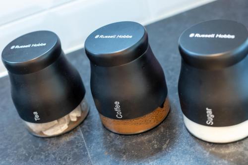 three black and white slippers sitting on a counter at CAPRI 13 SA - 3 Bedroom House close to Loughborough University, EV car facilities, Free Parking, Free Wifi - Ask for contractor rates! in Loughborough