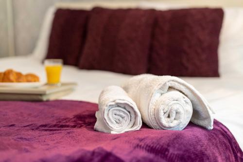 a pile of towels sitting on top of a bed at CAPRI 13 SA - 3 Bedroom House close to Loughborough University, EV car facilities, Free Parking, Free Wifi - Ask for contractor rates! in Loughborough