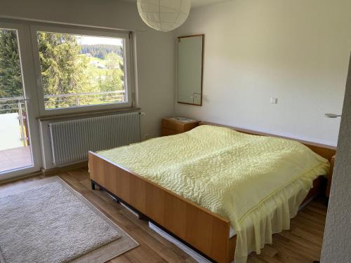 a bedroom with a bed and a large window at Haus Gutach in Schönwald