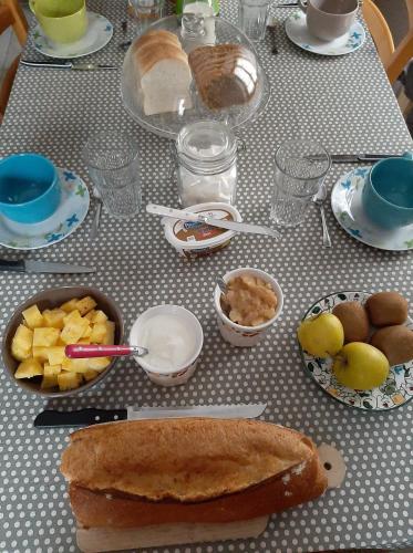 une table recouverte de assiettes et de bols de nourriture dans l'établissement Gîte la maison de Mika, à Saint-Floret