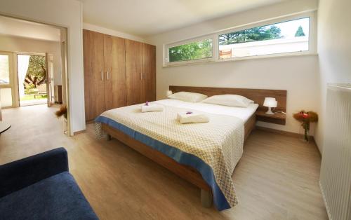 a bedroom with a bed with two towels on it at Adria Apartments - Hotel & Resort Adria Ankaran in Ankaran