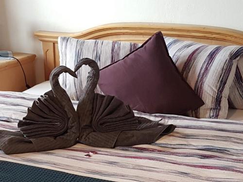 two swans made out of towels on a bed at Hotel Beau-Séjour in Leukerbad
